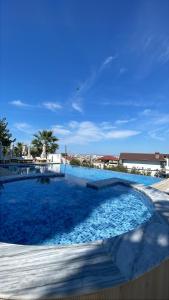 a large swimming pool with blue water at Hotel Aleksandrus Jardin in Durrës