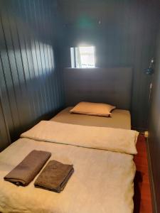 two beds in a small room with towels on them at Et soverom, delt bad in Fredrikstad