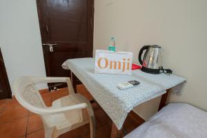 a table in a room with a chair and a box on it at Omji Ashram - Maa Anandmayi in Vrindāvan
