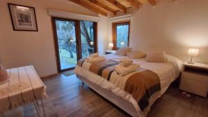 a bedroom with a large bed with towels on it at Green House B & B in Villa La Angostura
