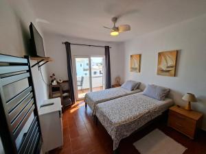a bedroom with two beds and a flat screen tv at Casa Svancy in Lagoa