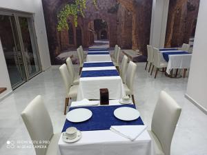 a long dining room with white tables and chairs at EnkayaHotel in Nicosia