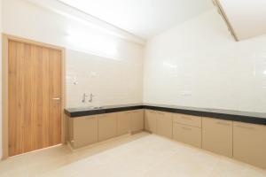 a kitchen with a sink and a wooden door at viyan stays in Coimbatore +70 photos