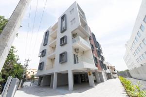 a white building with windows on a street at viyan stays in Coimbatore