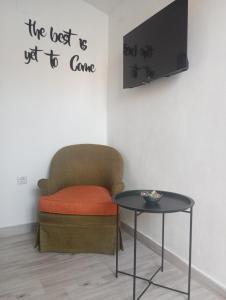 a room with a chair and a table and a tv at Basic in Kalamata