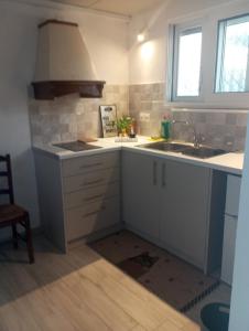 a kitchen with white cabinets and a sink and a window at Basic in Kalamata