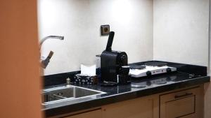 a kitchen counter with a sink and a microwave at Hotel Almou in Ouarzazate +86 photos