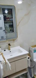 a bathroom with a white sink and a mirror at La maison blanche in Tinerhir