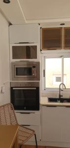 a kitchen with appliances and a table and a window at La maison blanche in Tinerhir