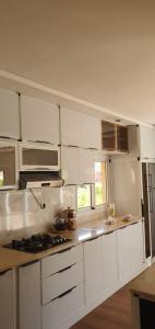 a kitchen with white cabinets and a stove top oven at La maison blanche in Tinerhir