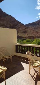 a patio with two chairs and a table on a deck at La maison blanche in Tinerhir