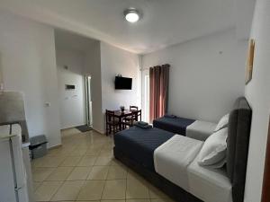 a hotel room with two beds and a table at Ksamil Apartament Sela in Ksamil