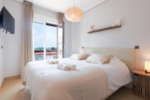 a bedroom with a large white bed with towels on it at Casa Avina Bliss in Los Alcázares +32 photos