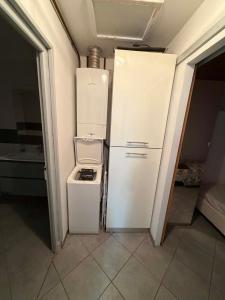 a white refrigerator in a kitchen with a trash can at Les Palmiers in Millau