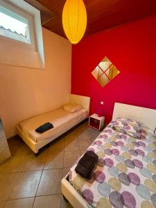 a bedroom with two beds and a red wall at Les Palmiers in Millau