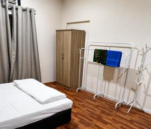 a room with a bed and a wooden cabinet at Liva Residency in Salalah