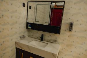 a bathroom with a sink and a mirror at Sabyinyo Crest in Cyuve +19 photos