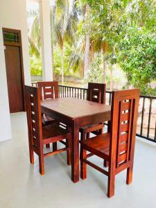 a wooden table and chairs sitting on a balcony at The Royal Ember in Arugam Bay +23 photos