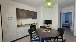 a kitchen with a table and a kitchen with a dining room at Casa Rose in Villaggio Azzurro