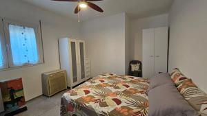 a bedroom with a bed and a ceiling fan at Casa Rose in Villaggio Azzurro