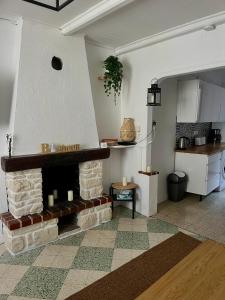 a living room with a brick fireplace and a kitchen at Charmant in Saint-Martin-Vésubie