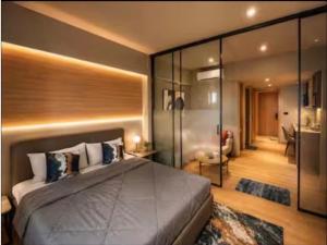 a bedroom with a large bed and glass walls at Elite Haven in Raipur +4 photos