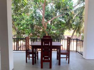 a table and chairs on a balcony with a tree at The Royal Ember in Arugam Bay