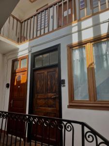 a house with two wooden doors and a balcony at Charmant in Saint-Martin-Vésubie