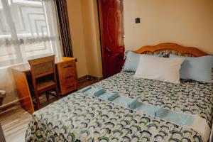 a bedroom with a bed and a table and a window at Sabyinyo Crest in Cyuve