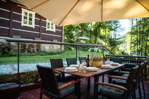 a table with chairs and an umbrella on a patio at Chalupa 47 in Hřensko