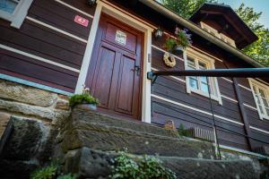 a wooden door on a house with a stone wall at Chalupa 47 in Hřensko