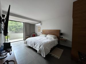 ein Schlafzimmer mit einem Bett und einem großen Fenster in der Unterkunft Casa Olié in Oaxaca de Juárez