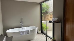ein Badezimmer mit einer weißen Badewanne und einem Fenster in der Unterkunft Casa Olié in Oaxaca de Juárez + 217 Fotos