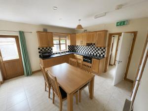 a kitchen with a wooden table and chairs in it at 28 Rathevan View Rosdarragh Portlaoise in Portlaoise