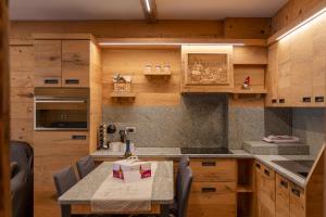 a kitchen with wooden cabinets and a table with chairs at BERTUZZI HOMES "Luxury Chalet" in Aprica