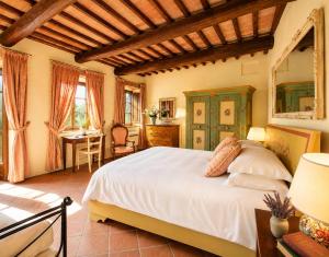 a bedroom with a bed and a desk in a room at Borgo Livernano in Radda in Chianti