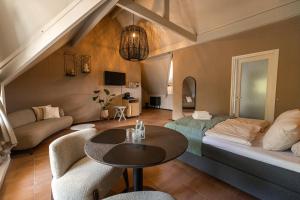 a living room with a bed and a table at Bed & Bos de 14 Sterren in Den Burg