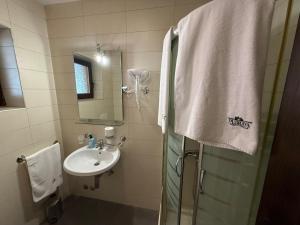 a bathroom with a sink and a shower with a towel at LUX Apartmani Dubrava in Ivanjica