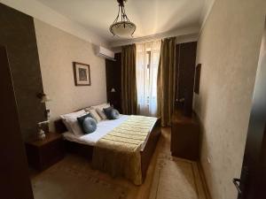 a bedroom with a bed with blue pillows and a window at LUX Apartmani Dubrava in Ivanjica