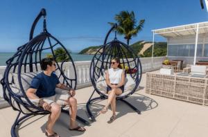 a man and a woman sitting in a spiderweb chair at SERHS Beach Hotel in Natal