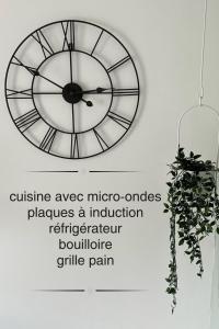 a clock hanging on a wall with a plant at La maison du Maréchal in Parthenay