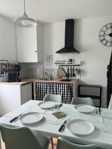 a kitchen with a white table and chairs and a kitchen with a table and chairs at La maison du Maréchal in Parthenay