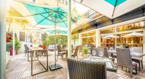 a restaurant with tables and chairs and umbrellas at Hôtel Montaigne & Spa - Cannes Centre in Cannes