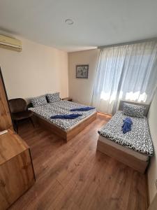 two beds in a room with wooden floors at Irene in Pawlikeni