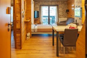 a room with a bed and a table and a bedroom at BERTUZZI HOMES "Luxury Chalet" in Aprica