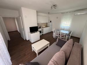 a living room with a couch and a table and a kitchen at Apartments Kuk in Šilo