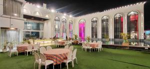a room with tables and chairs in a building at Sparsh Hotel & Resort in Bareilly