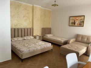 a living room with a bed and a couch at Amras house in Durrës