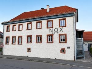 a white building with a nox hotel written on it at NOX HOTEL - Digital-Check-In & Virtual Reception - nahe Bretten & Karlsruhe in Wössingen