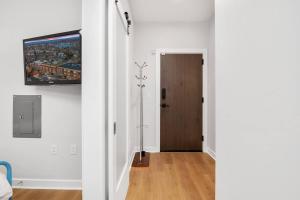 a hallway with a door and a television on a wall at Upscale Condo In Annapolis w/Private Parking in Annapolis